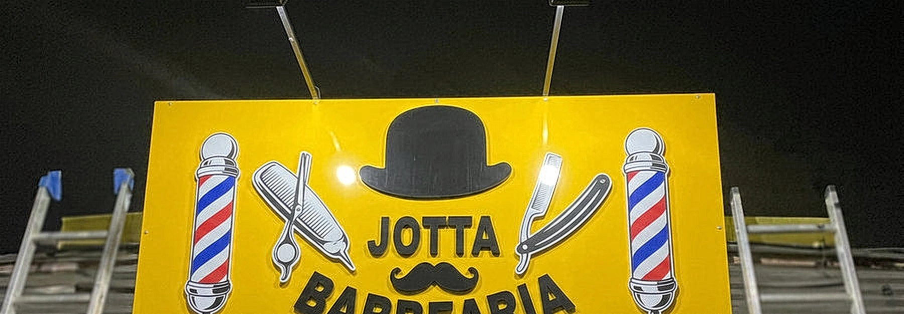 Fachada amarela de barbearia com letreiro luminoso em letras caixa instalado pela INOVE